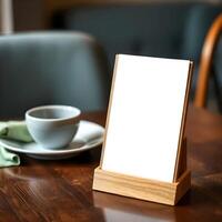 Mock up of a blank white board on a table with a cup of coffee photo