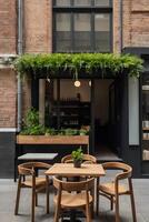 A table and chairs in front of a brick building photo