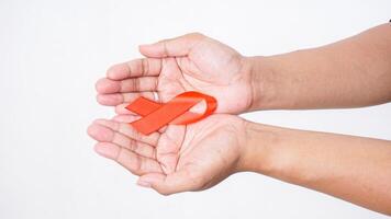 Hands showing red ribbon awareness on palm on white background photo