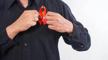 Man holding red ribbon on his chest as symbol of awareness isolated on white background photo