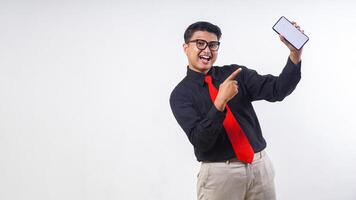 Smiling Asian employee business man corporate wearing formal clothes holding smartphone pointing at white mock up blank screen mobile cell phone for apps advertising isolated on white background photo
