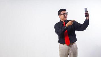 Happy Asian employee business man corporate wearing formal clothes pointing finger on mobile cell phone isolated on white background photo