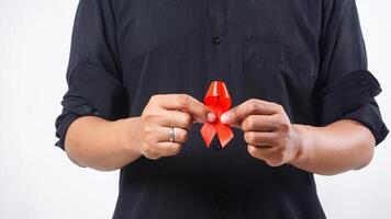 Man holding red ribbon as symbol of awareness isolated on white background photo