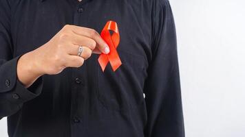 Man holding red awareness ribbon on his chest isolated on white background photo