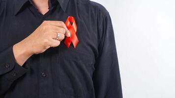 Man holding red awareness ribbon as symbol of support for people living with HIV AIDS isolated on white background photo