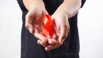 Red awareness ribbon in man hands isolated on white background photo