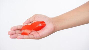 Red ribbon as HIV AIDS awareness symbol in man hands isolated on white background photo
