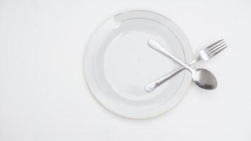 Spoon and Fork on a Plate Isolated on White Background photo