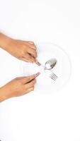 Hand with Spoon, Fork, and Round Plate Isolated on White Background photo
