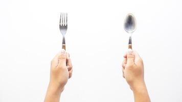 Hands Holding Spoon and Fork with Wooden Handle Isolated on White Background photo