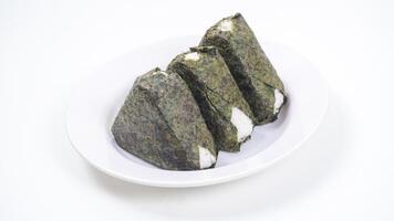 Triangular rice ball wrapped in nori on plate isolated on white background photo