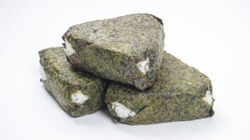 Japanese onigiri made from savory rice in triangular shaped wrapped in nori or seaweed isolated on white background photo