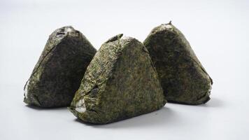 Three delicious onigiri or Japanese rice ball wrapped in nori dried seaweed on isolated on white background photo