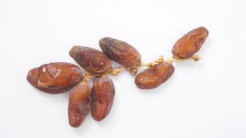 Delicious Dried Dates Fruit on Stalk Perfect for Iftar Isolated on White Background photo