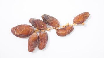 Brown Dried Dates Fruit on Stalk Nutritious Ramadan Snack Isolated on White Background photo