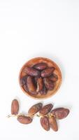Sun Dried Dates Fruit on Wooden Plate for Iftar Fasting Isolated on White Background photo