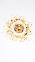 Top view of healthy granola mix with oats, nuts, and dried fruits on bowl isolated on white background photo