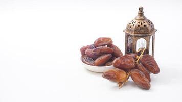 Dry Dates Fruit on Bowl for Ramadan Iftar with Islamic Lantern Isolated on White Background photo