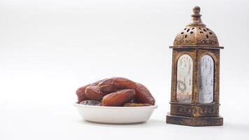 Dates Fruit on Bowl for Ramadan Iftar with Islamic Lantern Isolated on White Background photo