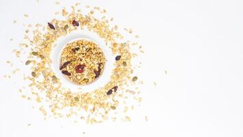 Top view of nutritious granola with oats, nuts, and dried fruits on bowl isolated on white background photo