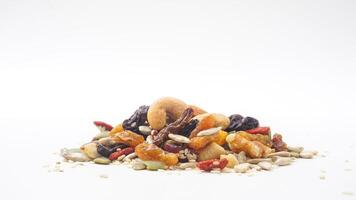 Delicious combination of nuts seeds and dried fruits isolated on white background photo