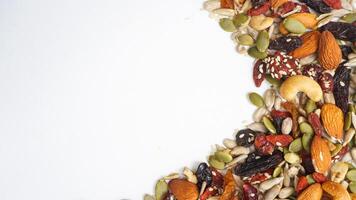 Perfect snack mix of nuts seeds and dried fruits isolated on white background photo