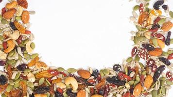 Assorted crunchy nuts seeds and dried fruits isolated on white background photo
