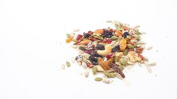 Selection of mixed nuts seeds and dried fruits isolated on white background photo