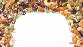 Organic nuts seeds and dried fruits mixture isolated on white background photo