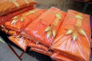 Orange robes with lotus flowers for offering to monks during the Kathin ceremony photo