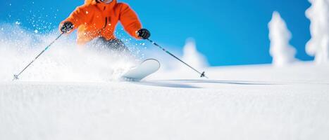 skier in orange jacket gracefully descends snowy slope, creating spray of powder against bright blue sky. scene captures thrill of winter sports photo