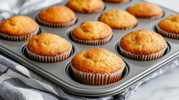 Freshly baked homemade muffins in baking tray, golden brown and fluffy, ready to be enjoyed. photo