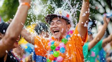 Joyful man celebrating Songkran festival, splashed with water, colorful beads photo