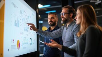 Three people standing around a whiteboard with a diagram on it photo