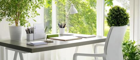 Elegant minimalist workspace featuring monochromatic desk, greenery, and natural light photo