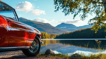 vintage car parked by tranquil lake, surrounded by mountains and trees, evokes sense of peace and nostalgia photo