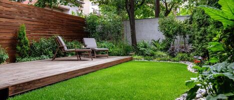 A backyard with a wooden deck and grass photo