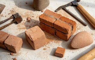 Brick laying activity with various masonry tools displayed on work surface photo