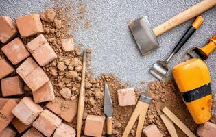 Brick laying tools and materials arranged on surface, showcasing various masonry tools and bricks photo