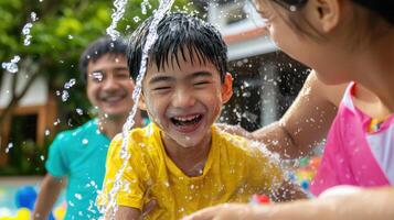 Happy children playing in water during family gathering, enjoying Songkran Festival photo