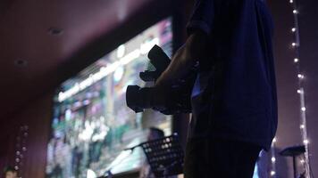 A man holding a camera in front of a large screen photo