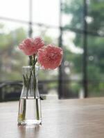 A vase with pink flowers sitting on a table photo