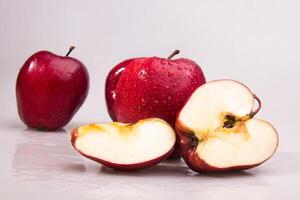 Fresh Red apple with cut in half and water droplets isolated on white background photo