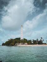 A lighthouse on an island surrounded by trees photo