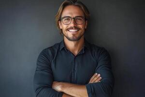 Professional man smiling with arms crossed against a dark background in a casual setting photo