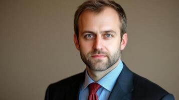 Professional man with a beard wearing a suit and tie poses for a portrait in an elegant indoor setting photo