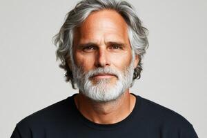 Mature man with silver hair and beard posing confidently against a neutral background photo