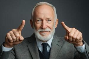 Smiling older man with a beard points at the camera in a well-fitted suit and blazer photo
