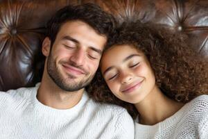 Happy couple relaxing together on a couch in a cozy indoor setting in warm soft sweaters photo