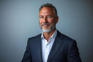 Professional man with gray beard in a tailored suit smiles against a neutral background photo